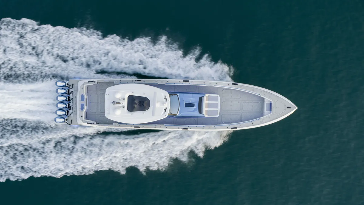 A powerboat moving through turquoise water, viewed from above