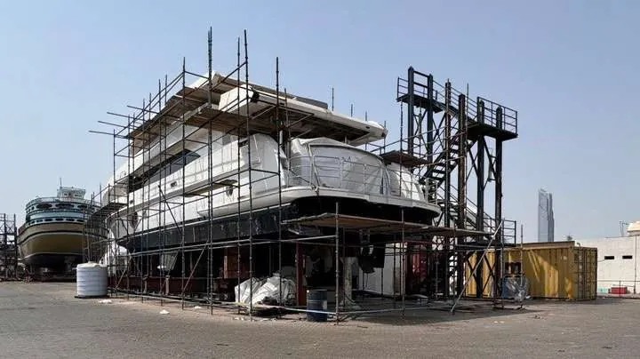 A yacht supported ashore with scaffolding around the superstructure