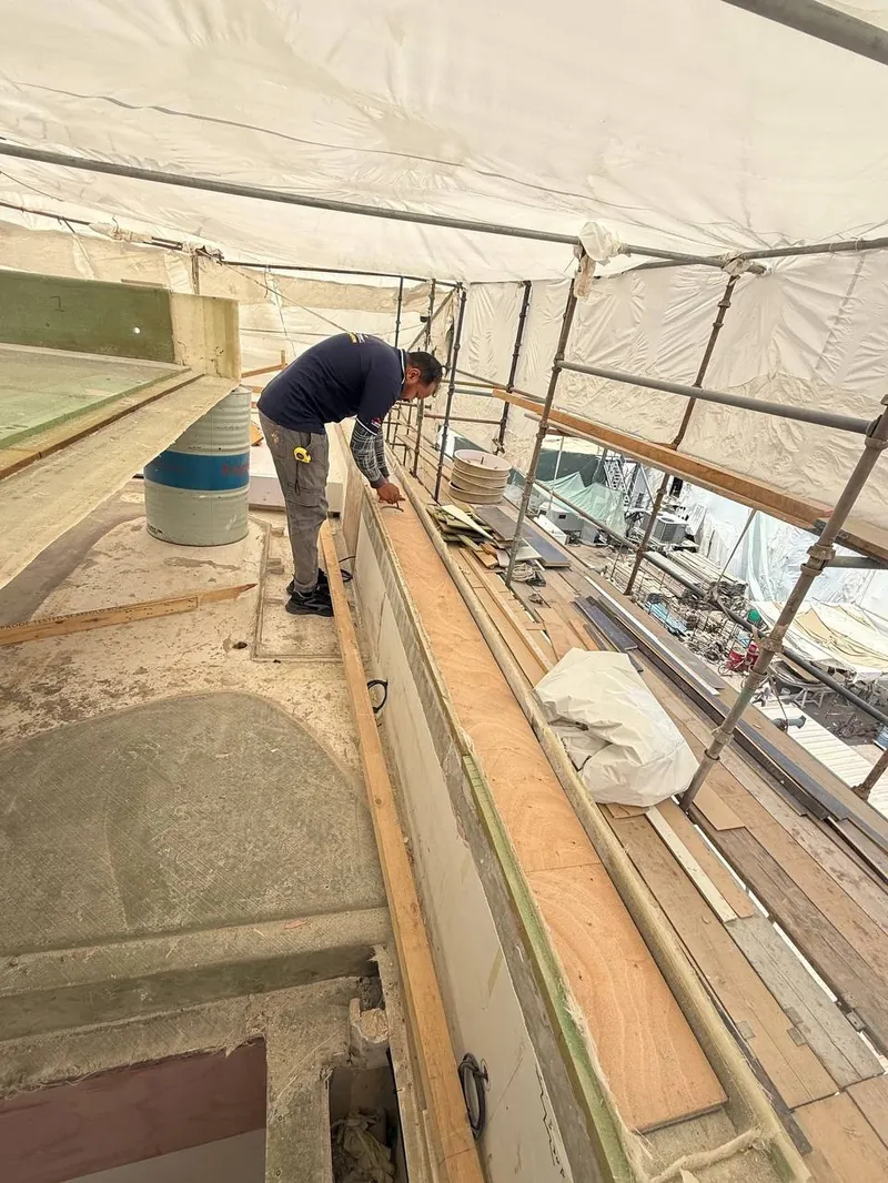 A technician working on the exterior deck during refit